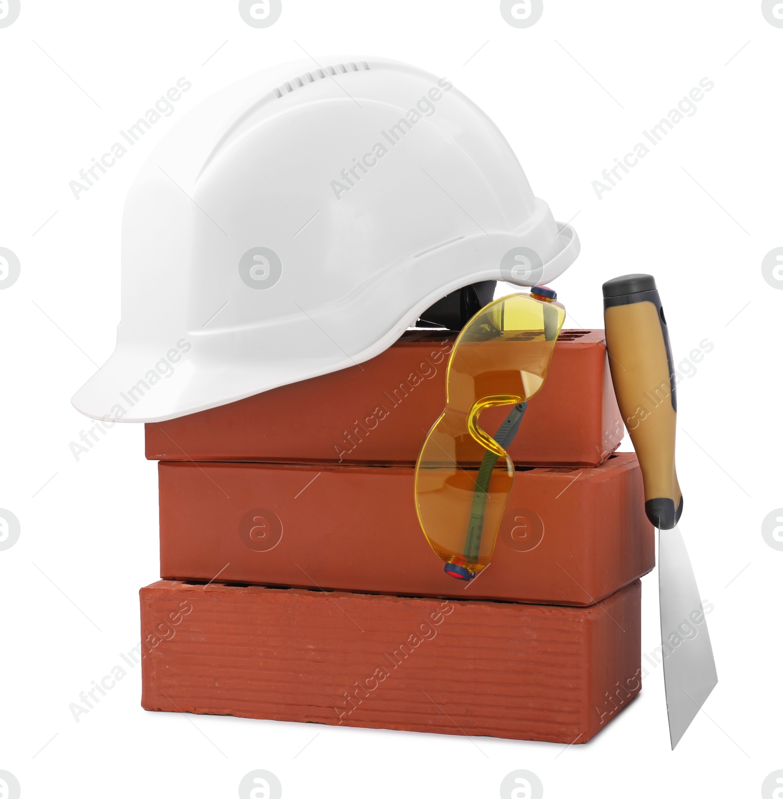 Photo of Protective equipment, bricks and construction tool isolated on white