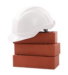 Photo of Hardhat with bricks isolated on white. Construction materials and safety equipment