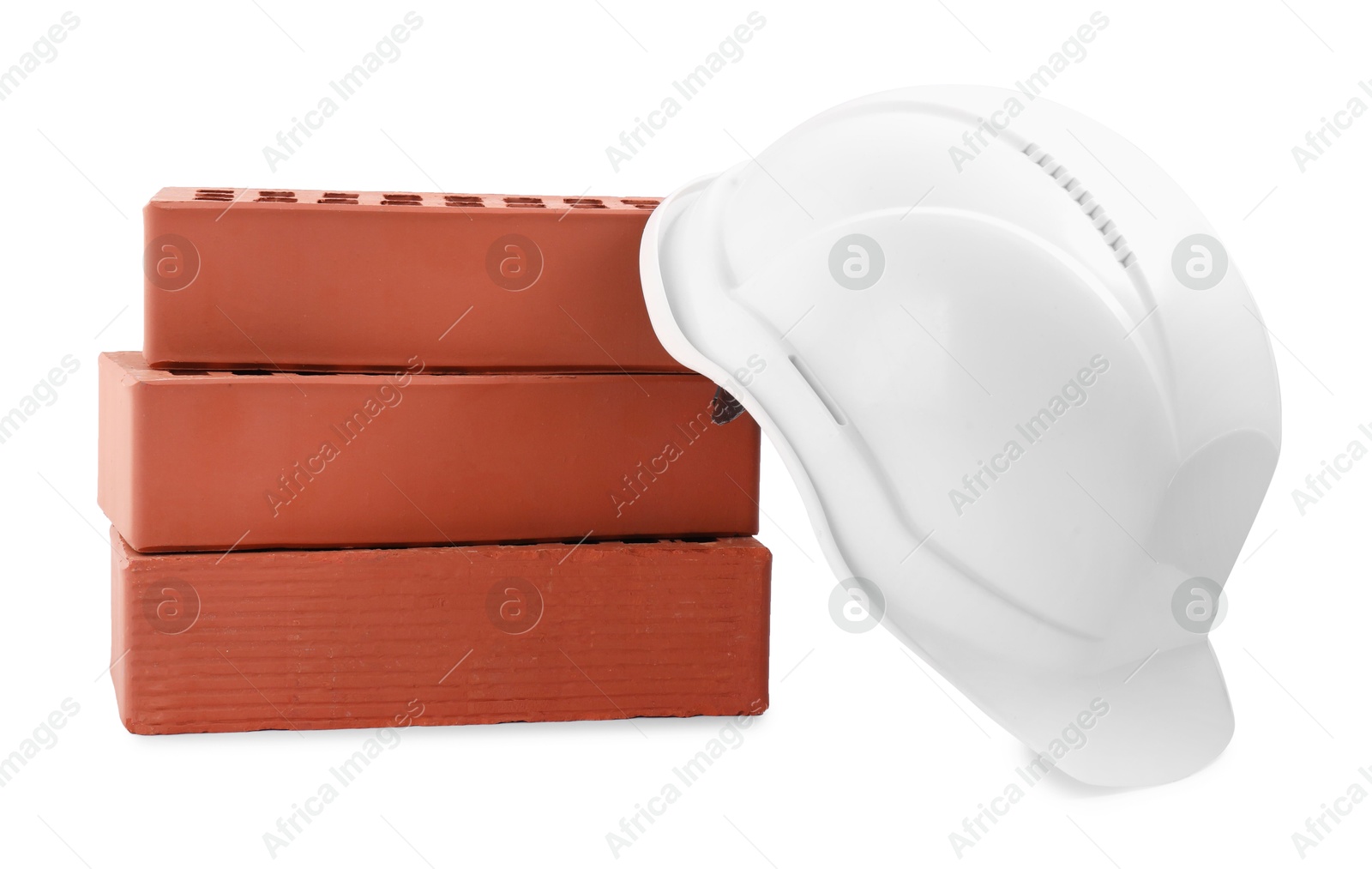 Photo of Hardhat with bricks isolated on white. Construction materials and safety equipment