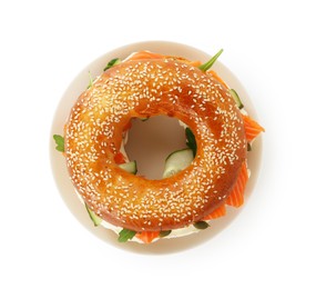 Photo of Delicious bagel with salmon, cream cheese and cucumber isolated on white, top view