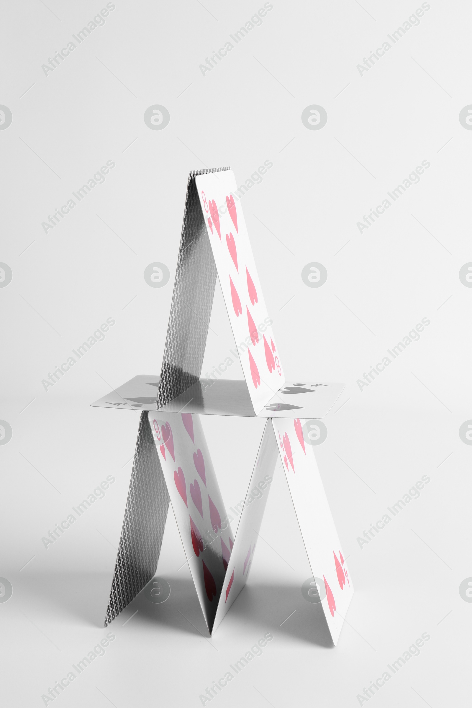 Photo of House of playing cards isolated on white