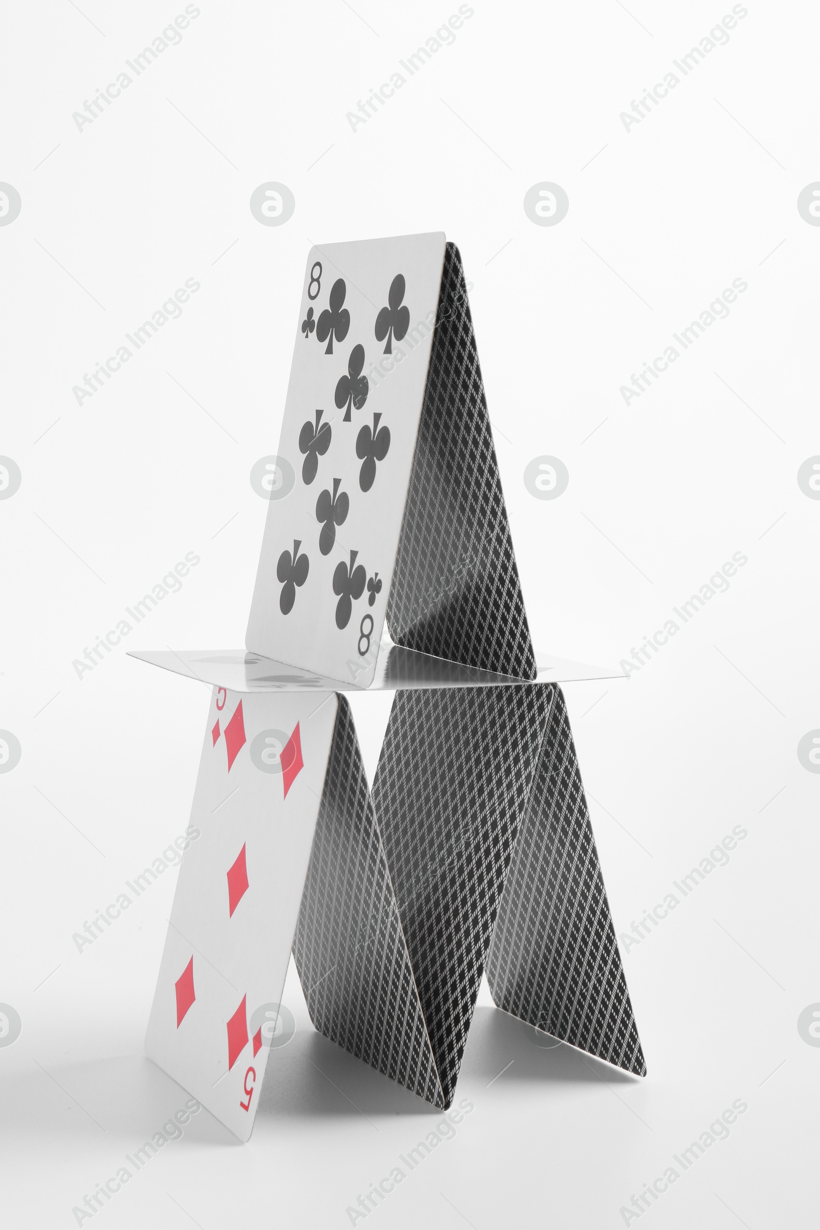 Photo of House of playing cards isolated on white