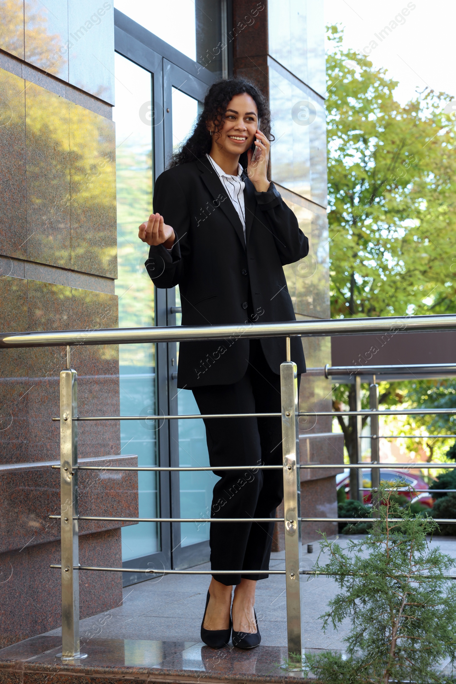 Photo of Portrait of young woman with phone wearing stylish suit outdoors