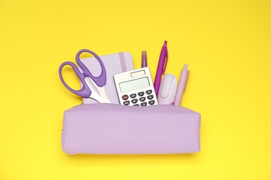 Photo of Pencil case and different stationery on yellow background, flat lay