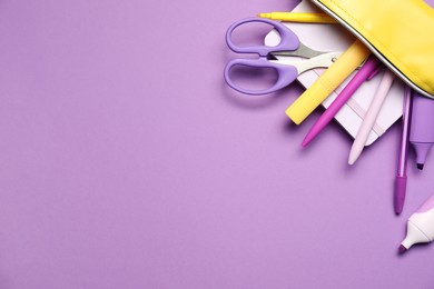 Photo of Pencil case with different stationery on purple background, flat lay. Space for text