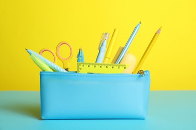 Photo of Different stationery in pencil case on color background