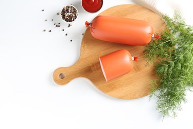 Photo of Tasty boiled sausages, ketchup and spices on white table, top view. Space for text