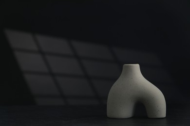 Photo of Stylish ceramic vase on black background. Space for text