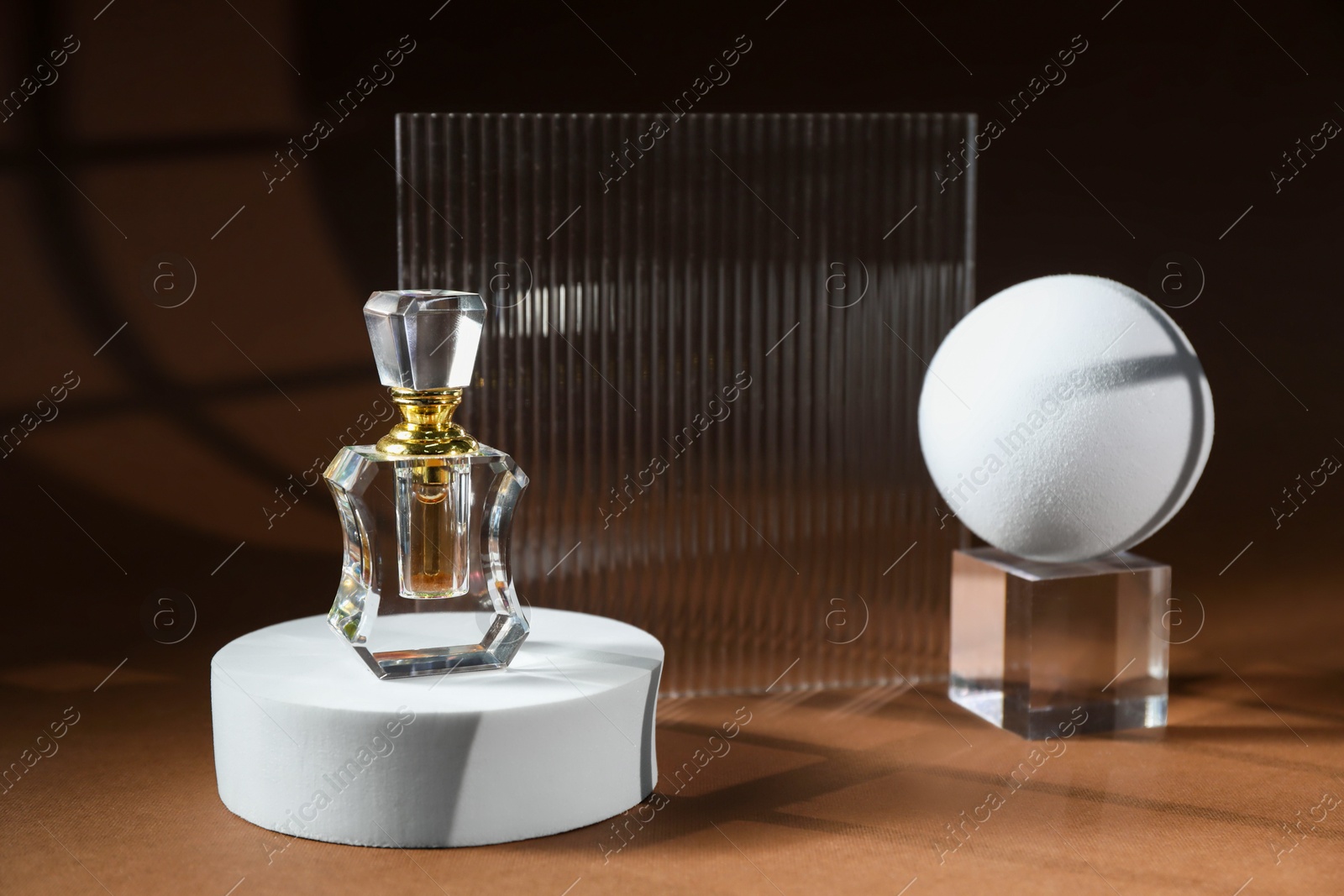 Photo of Stylish presentation of perfume bottle on brown background