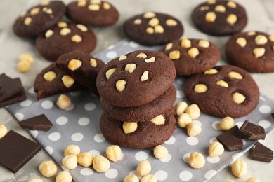 Photo of Tasty chocolate cookies with hazelnuts on table, closeup