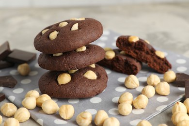 Photo of Tasty chocolate cookies with hazelnuts on table, closeup