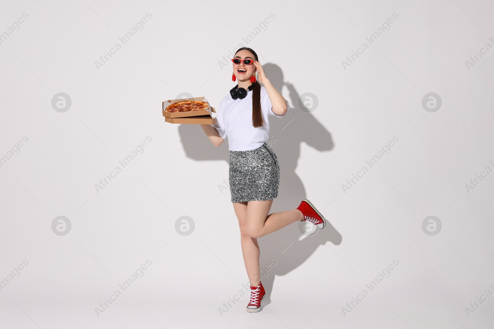 Photo of Woman in sunglasses with delicious pizza on white background