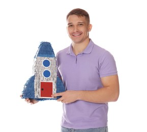 Photo of Happy man with pinata in shape of spaceship on white background