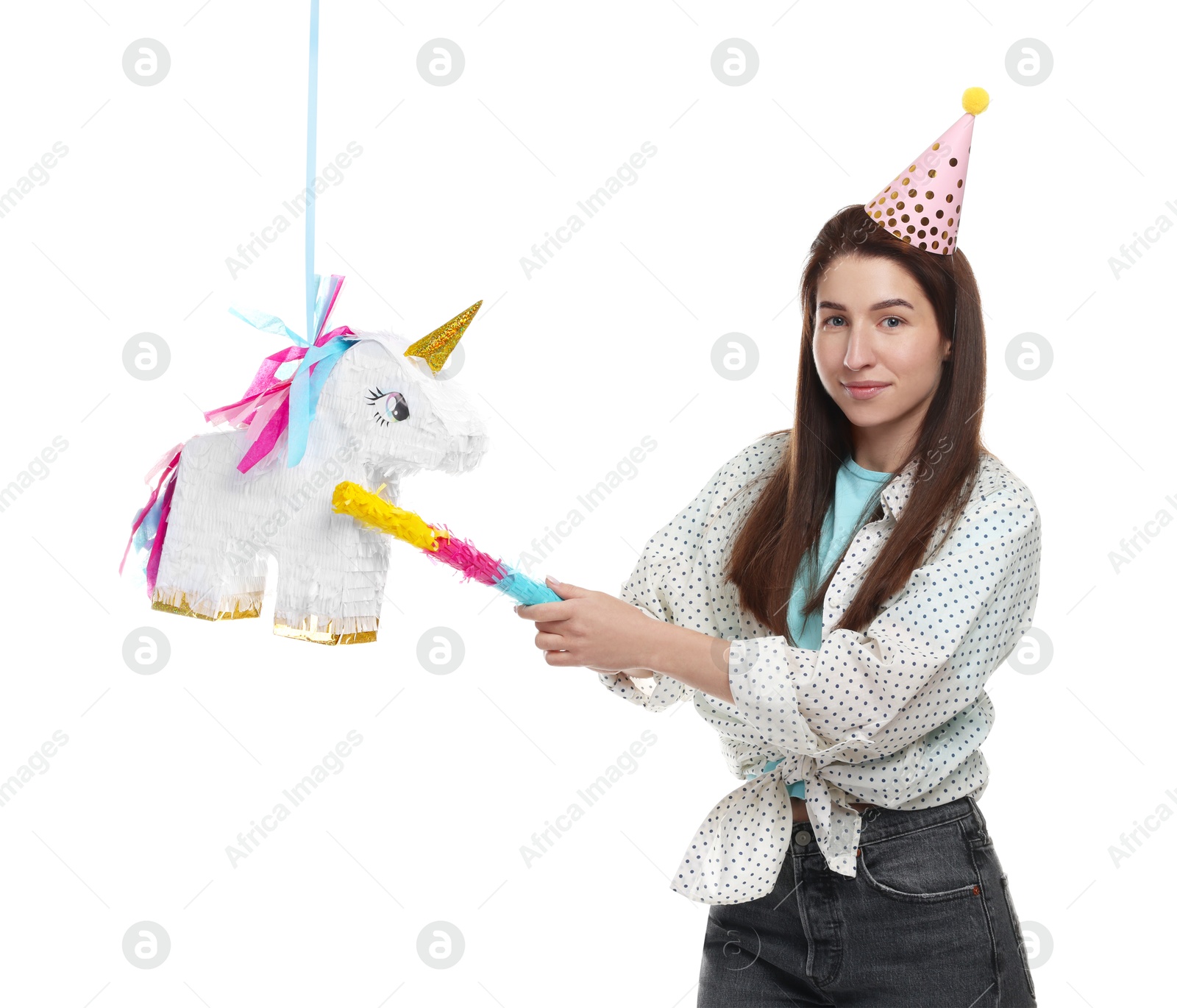 Photo of Woman hitting unicorn shaped pinata with stick on white background