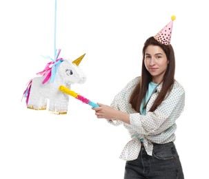 Photo of Woman hitting unicorn shaped pinata with stick on white background