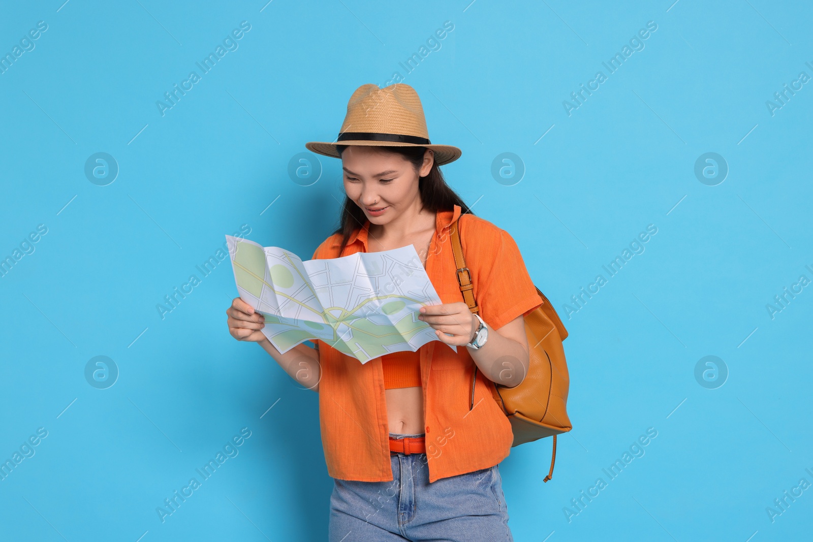 Photo of Traveller with backpack and map on light blue background