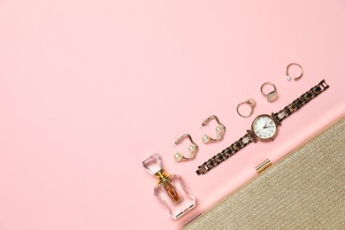 Photo of Many stylish jewelry, perfume and accessories on pink background, flat lay. Space for text