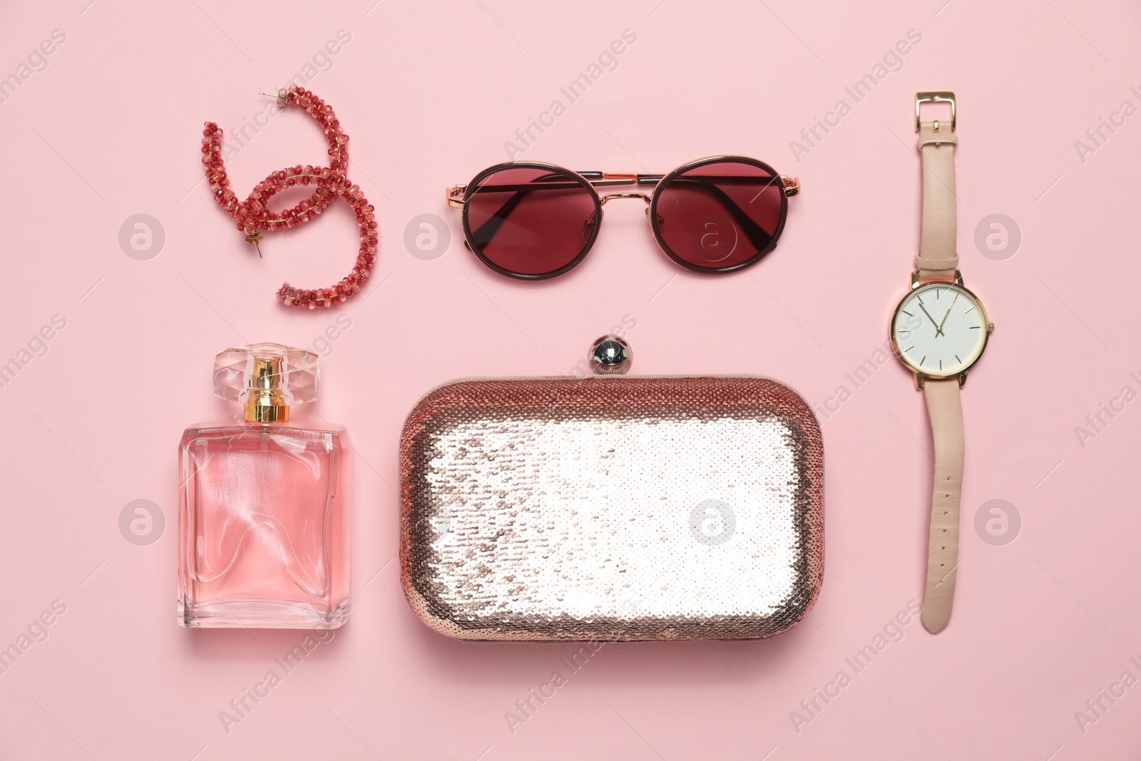 Photo of Stylish jewelry, perfume and accessories on pink background, flat lay