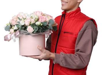 Photo of Smiling delivery man holding gift box with beautiful floral composition on white background, closeup