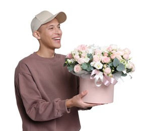 Photo of Smiling delivery man holding gift box with beautiful floral composition on white background