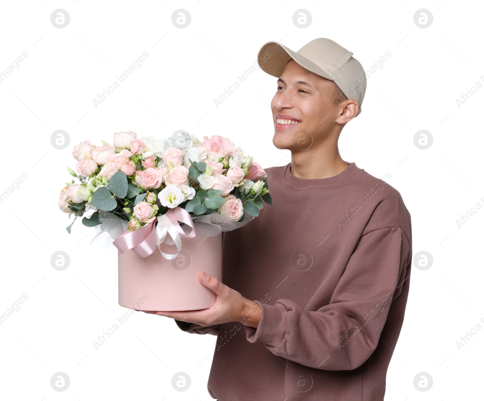 Photo of Smiling delivery man holding gift box with beautiful floral composition on white background