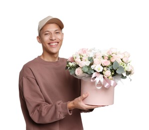 Photo of Smiling delivery man holding gift box with beautiful floral composition on white background