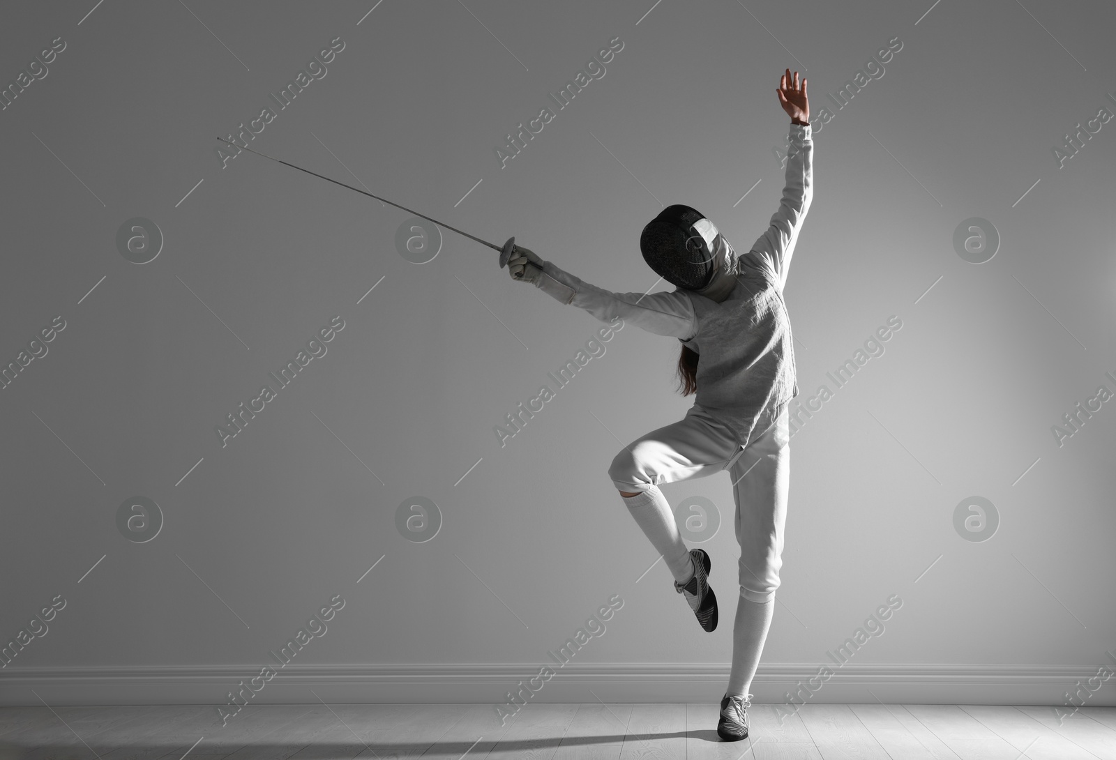 Photo of Fencer with epee practicing indoors. Combat sport