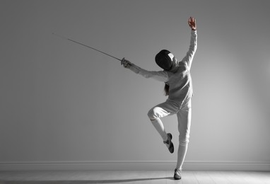 Photo of Fencer with epee practicing indoors. Combat sport