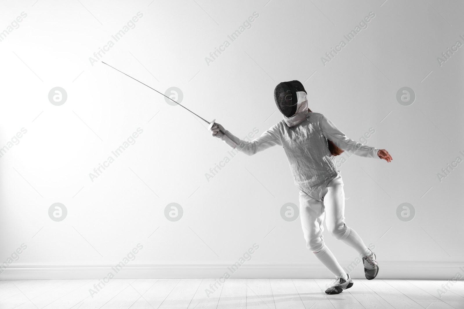 Photo of Fencer with epee practicing indoors. Combat sport