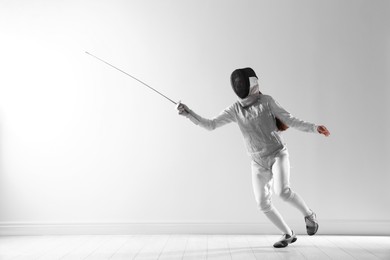 Photo of Fencer with epee practicing indoors. Combat sport