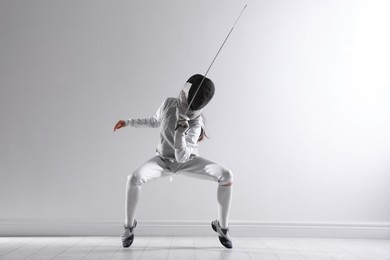 Photo of Fencer with epee practicing indoors. Combat sport