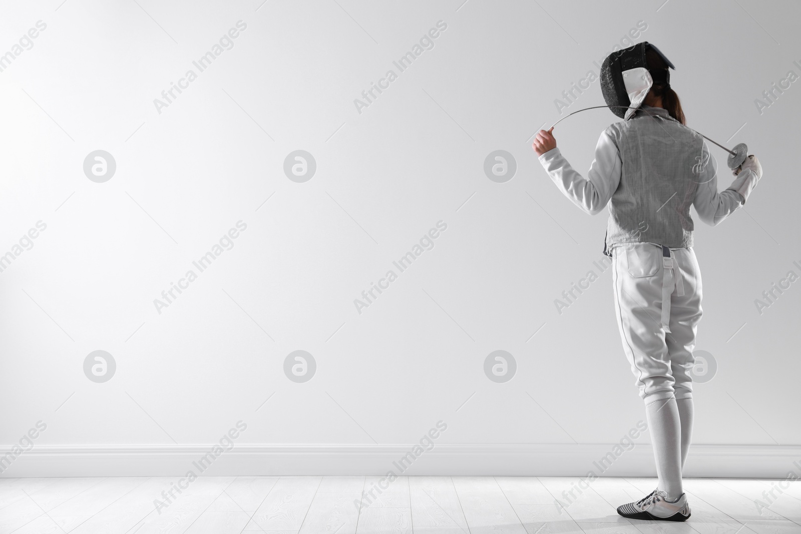 Photo of Fencer with epee indoors, space for text