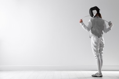 Photo of Fencer with epee indoors, space for text