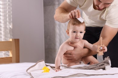 Photo of Man combing hair of his little baby indoors, space for text