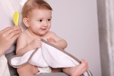 Photo of Woman brushing hair of her little baby indoors, closeup. Space for text