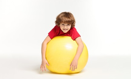 Photo of Little boy with fitness ball on white background