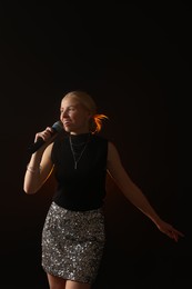 Photo of Beautiful talented singer performing on dark background