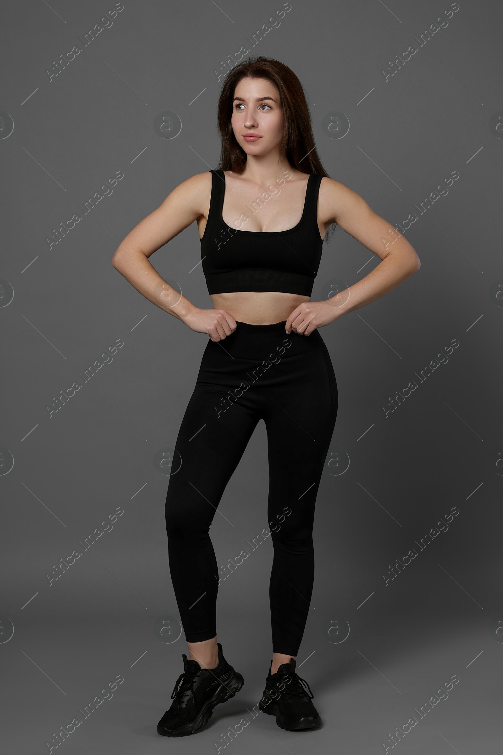 Photo of Portrait of woman in sportswear on grey background