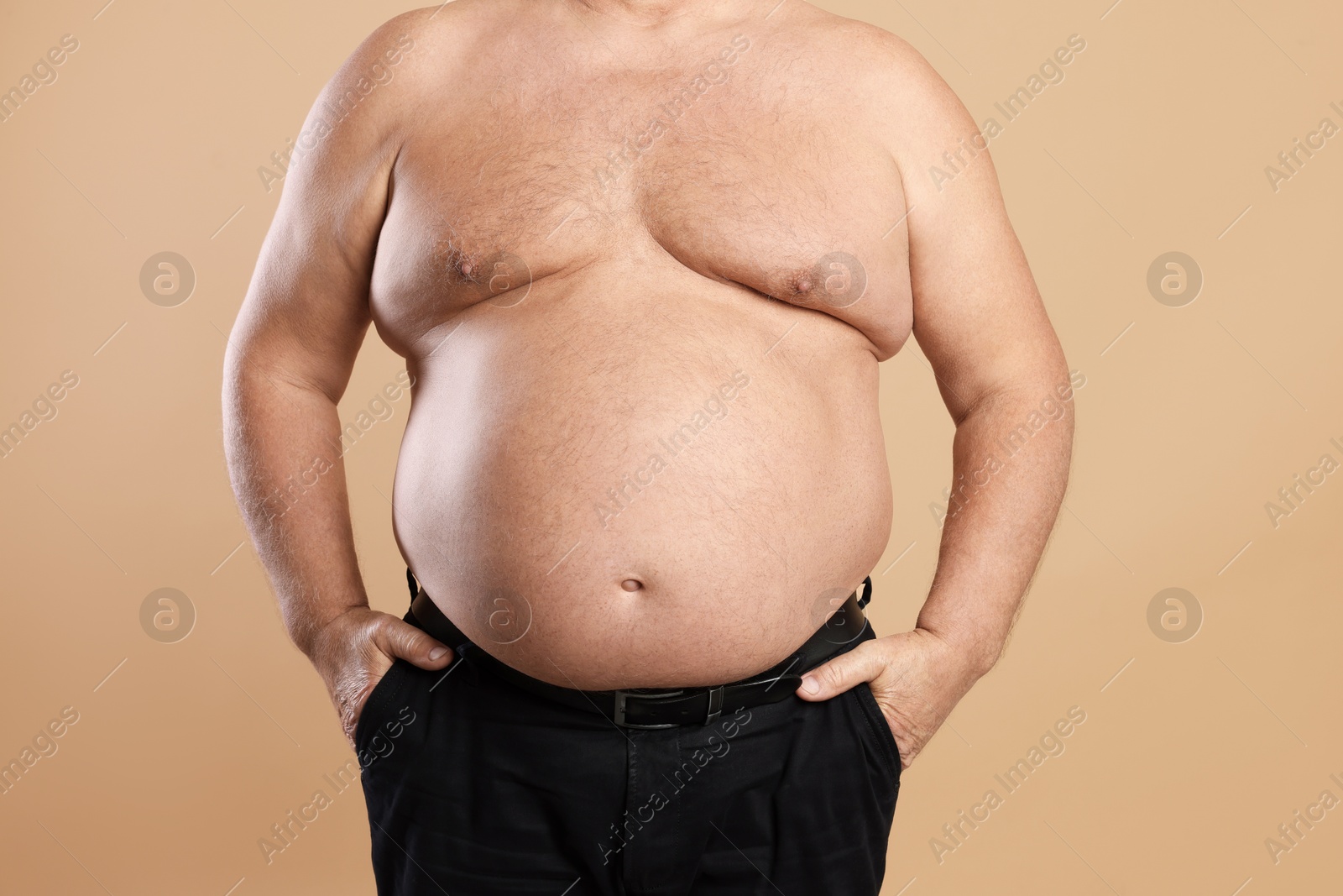 Photo of Man with excessive belly fat on beige background, closeup. Overweight problem