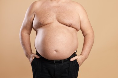 Photo of Man with excessive belly fat on beige background, closeup. Overweight problem