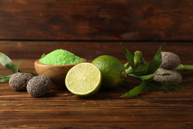 Photo of Spa composition with fresh limes, sea salt, stones and bamboo on wooden table