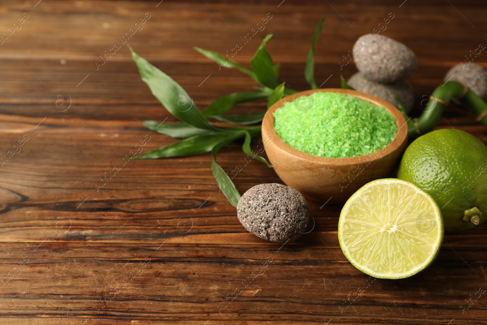 Spa composition with fresh limes, sea salt, stones and bamboo on wooden table, closeup. Space for text Photo of Spa composition with fresh limes, sea salt, stones and bamboo on wooden table, closeup. Space for text