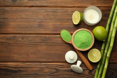 Photo of Spa composition with fresh limes, sea salt and bamboo stems on wooden table, flat lay. Space for text