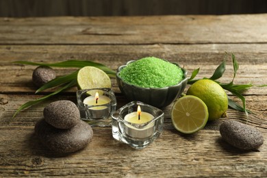 Photo of Spa composition with fresh limes, sea salt and burning candles on wooden table