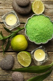 Photo of Spa composition with fresh limes, sea salt and burning candles on wooden table, flat lay