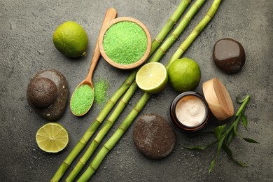 Photo of Spa composition with wet limes, sea salt, pebble stones and bamboo stems on grey table, flat lay
