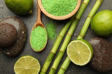 Photo of Spa composition with wet limes, sea salt, pebble stones and bamboo stems on grey table, flat lay