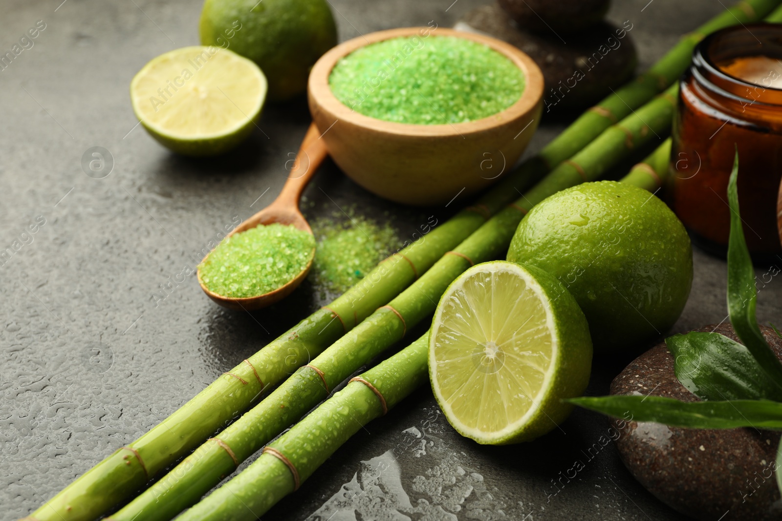 Spa composition with wet limes, sea salt, pebble stone and bamboo on grey table, closeup Photo of Spa composition with wet limes, sea salt, pebble stone and bamboo on grey table, closeup
