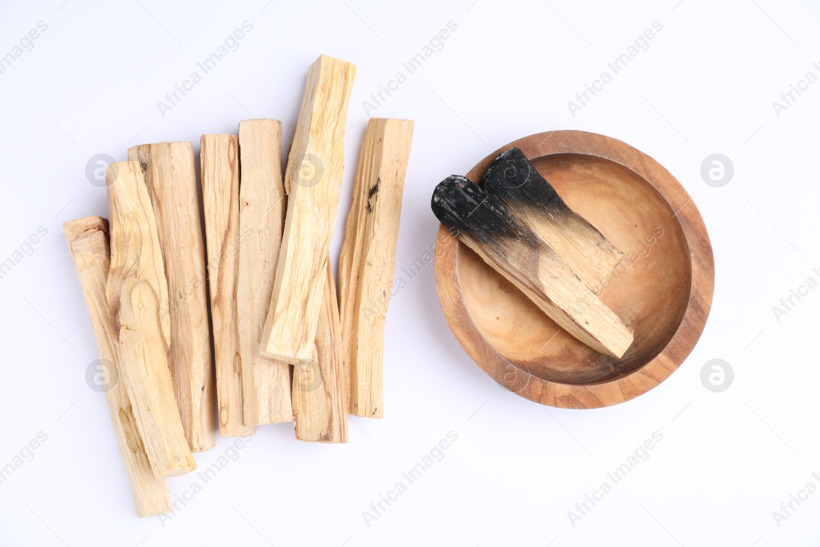 Photo of Whole and burnt palo santo sticks on white background, flat lay