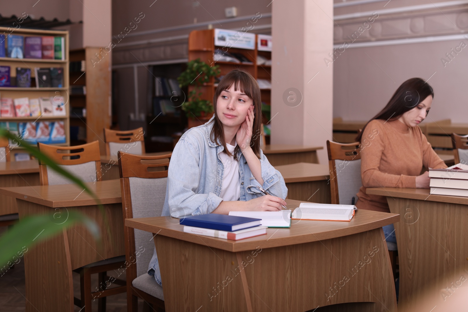 Photo of Beautiful women with books at desks in public library